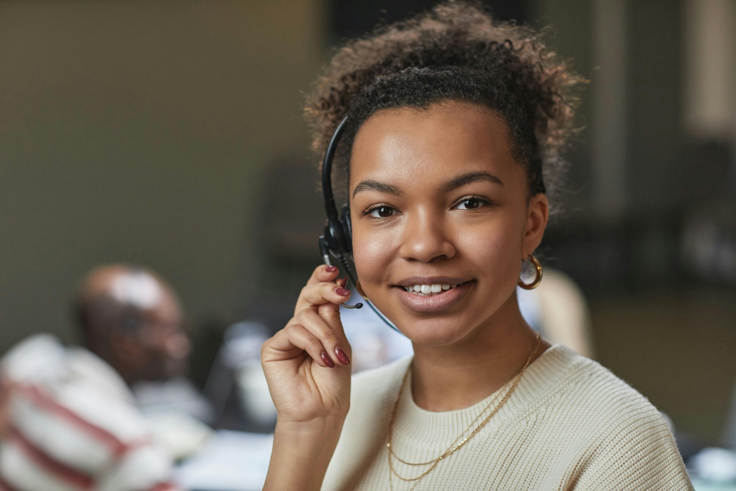 Smiling IT support professional wearing headphones and holding mic
