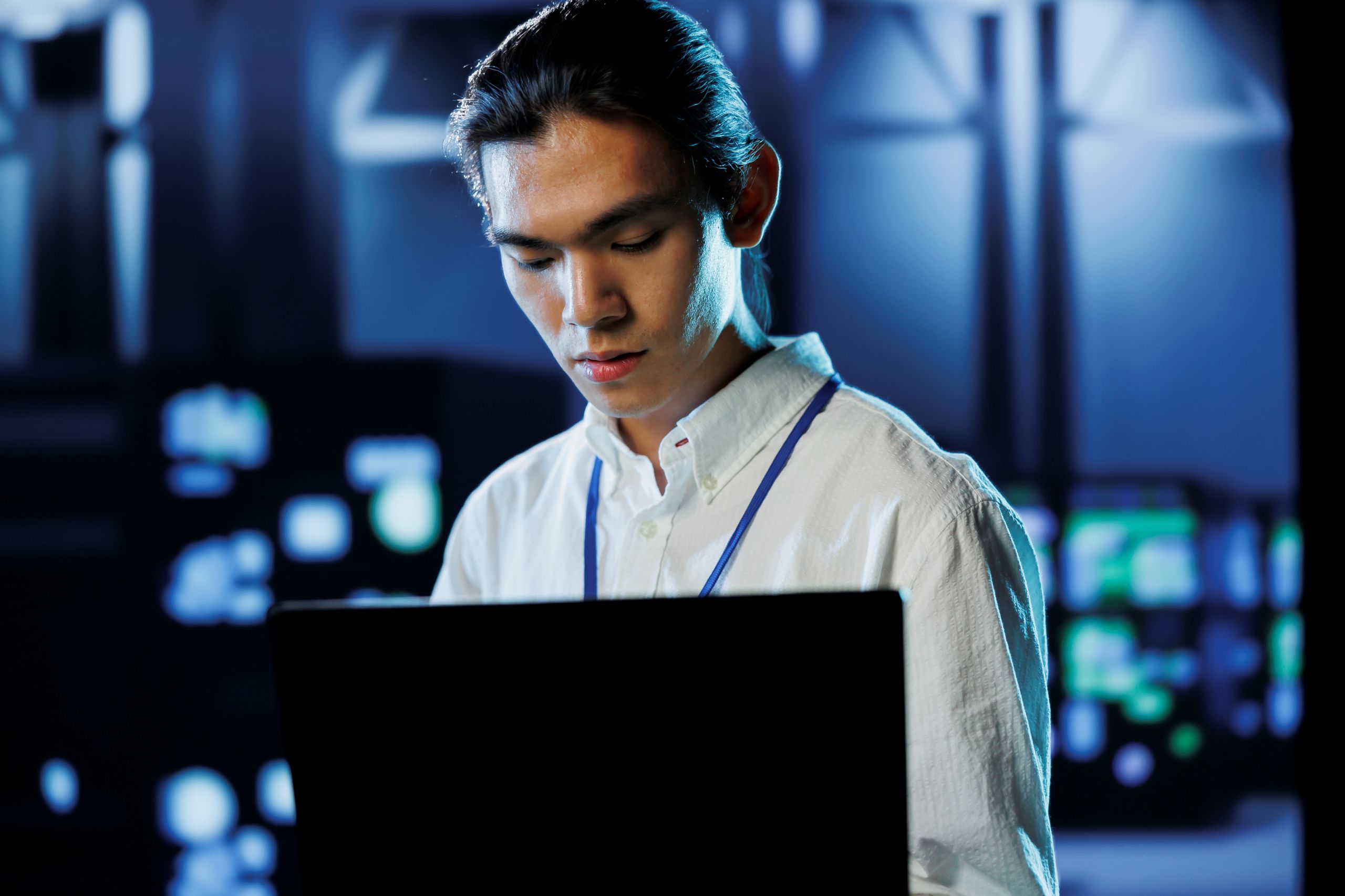 Engineer using laptop inside data center